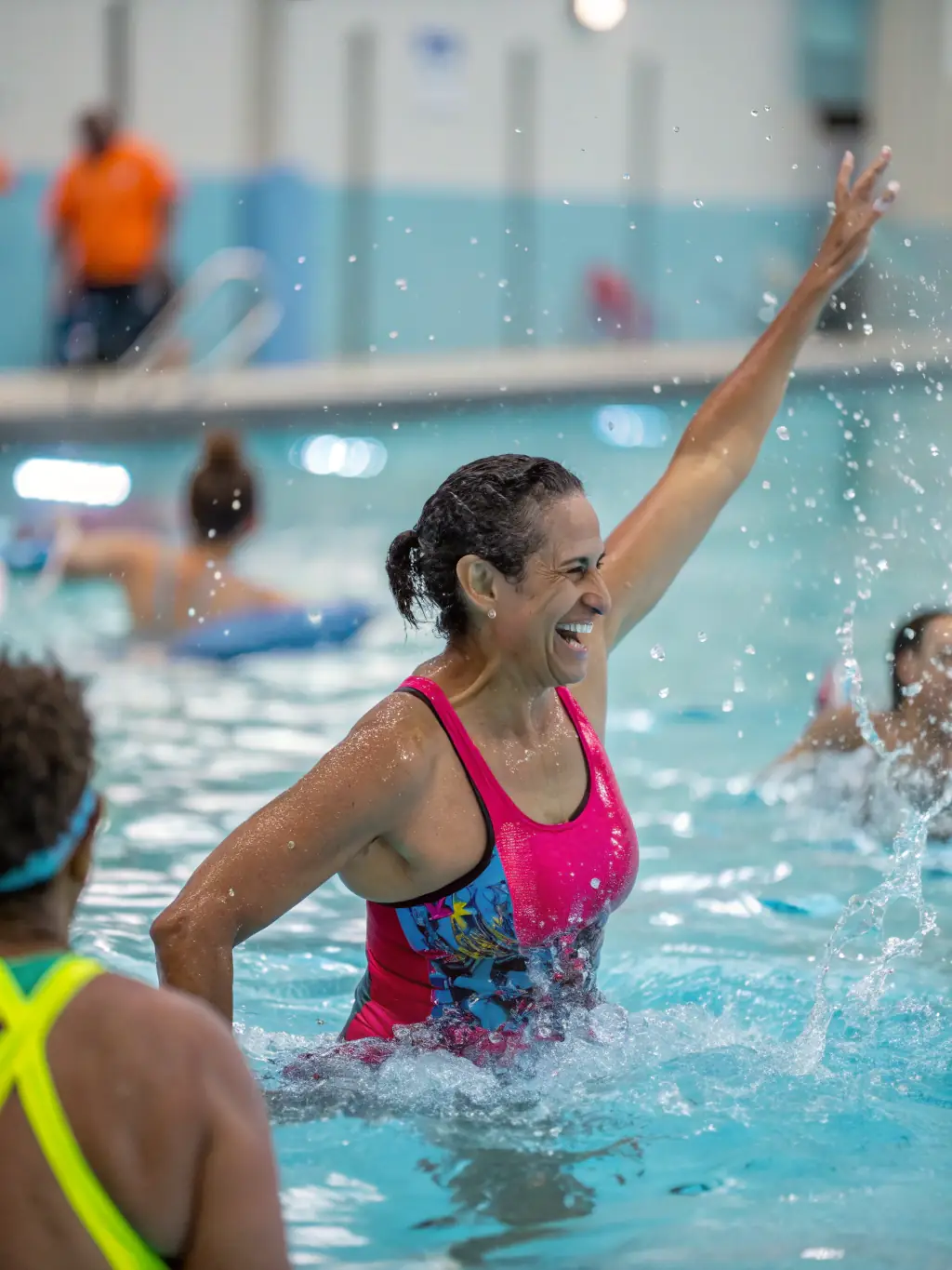 A senior citizen participating in a water aerobics class, with gentle movements and supportive instructors at ASS INTERCOM PISCINE DE LA PIMPERADE.